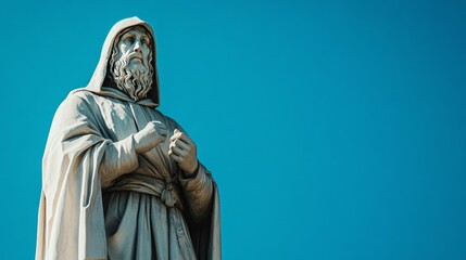 Fototapeta premium Ancient Hooded Sage Marble Statue Pointing to the Sky Depicting Wisdom and Knowledge Under Blue Skies