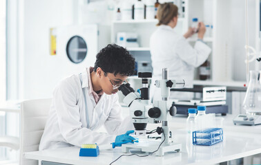 Scientist, research and woman with microscope in laboratory for medical sample, review and...