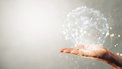 Hand holding a holographic sphere with interconnected nodes and labels on a light background, representing global data and technology concepts.