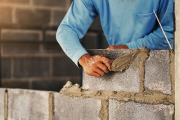 man is laying bricks on a wall