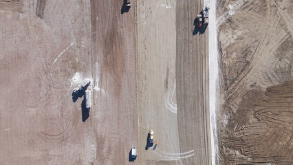 Earthmoving equipment. Aerial view of a large construction site with several earthmoving machines.