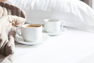 Fresh Cozy morning coffee on the white bed with white pillow near window in the sunny day. Lifestyle & Valentine Concept