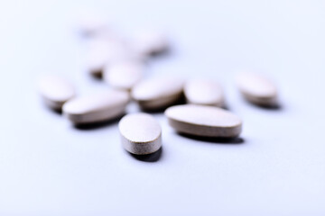 Ashwagandha (Withania somnifera) tablets. Concept for a healthy dietary supplementation. Bright paper background. Close up. Copy space.