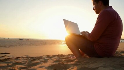 working on laptop at sunset on beach during peaceful evening, relaxation and productivity