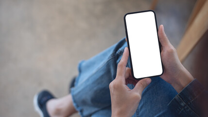 Cell phone white blank screen mockup, woman's hand holding mobile phone with blank screen and a cup of coffee in coffee shop, overhead shot, social media marketing design