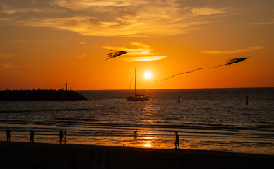 Sunset over the sea on the coast of Netherlands with sailing boat