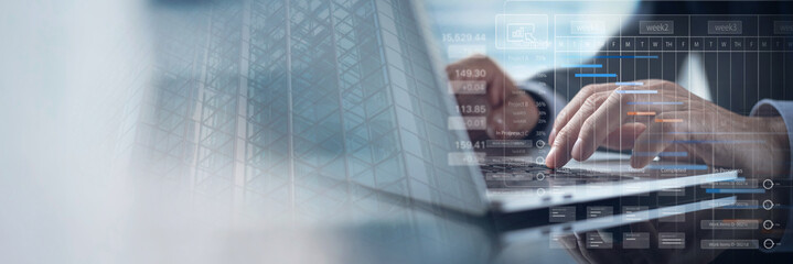 Project management system. Businessman project manager working on laptop and updating tasks and milestones progress planning with Gantt chart scheduling interface for business