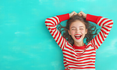 Girl with curly hair smiles joyfully against a teal background
