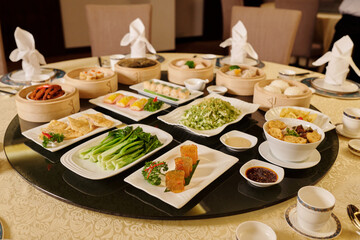 Various dishes serving on plates on round table in the restaurant