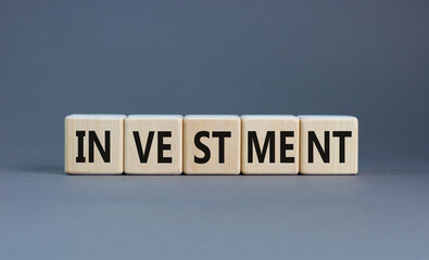 Investment symbol. Concept word Investment on beautiful wooden blocks. Beautiful grey background. Business investment concept. Copy space.