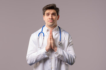 Mature 30s doctor man Praying, Begs Apologize, Guilty on White. Hopeful Prayer