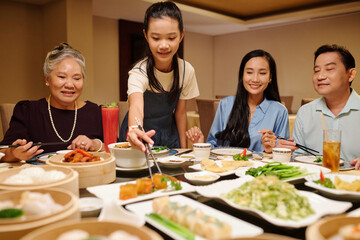 Asian family eating rolls at dining table in the restaurant