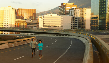Obraz premium Urban, workout and couple on street running together for sports training, commitment and body health. Evening, man and woman on road for fitness, exercise or outdoor wellness challenge on city bridge