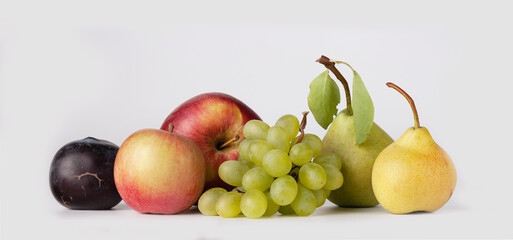 plums, apples, pears, grapes on a white background, a copy of the space, a banner