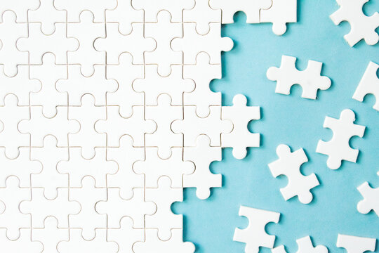 messy white jigsaw puzzles on blue background