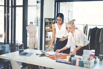 Women, fashion and designers with garment at workshop for material, design or teamwork at office. Young, female person or tailors working together on clothing line for style, size or production