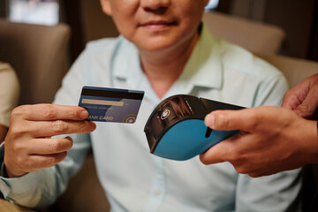 Close-up of man paying with credit card for his dinner in the restaurant