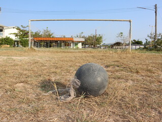 The Old soccer ball on the grass with a soccer goal