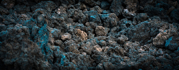 Black lava formations, basalt rocks closeup at the foot of a volcano.