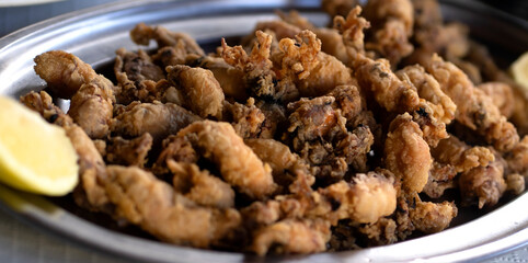 A plate with fried small delicious cuttlefish, grilled seafood closeup.