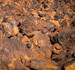 Lava formations, stones, black basalt in the rocks closeup on a volcano terrain.