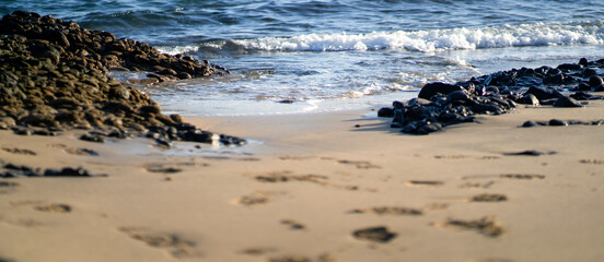 A beautiful ocean, a coastline with a volcanic sandy beach in a daylight.