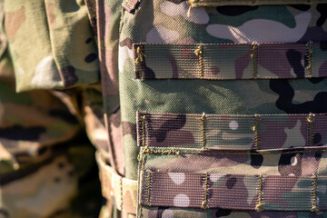 A military uniform with a body armor in camouflage closeup.