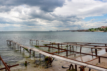 Fototapeta premium Rusty slipways and wooden piers under dark cloudy sky at the Fishing port of Ravda, Nesebar municipality, Burgas Province, Bulgarian Black Sea coast