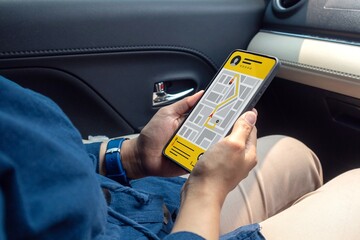 Woman in a car ordering taxi online using mobile app on smart phone. Booking taxi online concept.