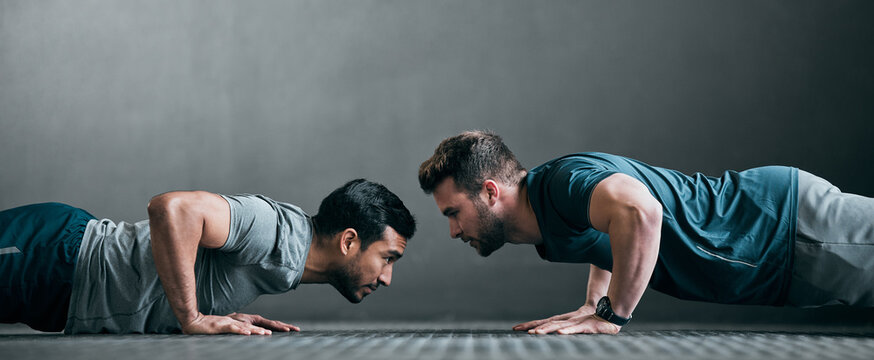 People, team and push up in gym for fitness, strong muscle development and support together. Men, friends and confident in exercise routine at health center, personal trainer and coaching client