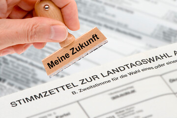 Ein Holzstempel ist beschriftet mit dem Aufdruck: Meine Zukunft über einem Stimmzettel zur...