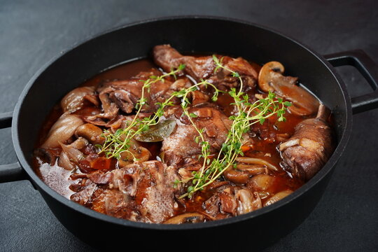 Coq au vin or rooster, cock with wine. French dish of chicken marinated in Burgundy sauce braised with red wine, bacon, mushrooms, and onion. Seasoned with salt, pepper, thyme