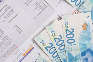 Rishon Lezion, Israel – 24.08.2024. Electricity company Hevrat Hashmal and Municipality tax Arnona Invoice. Rising prices, economic crisis in Israel shekels. Written in Hebrew: months and prices.