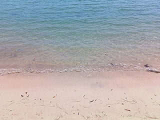 Soft blue ocean wave on fine sandy beach background