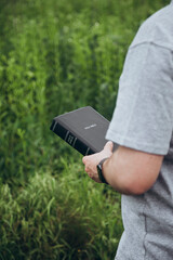 Christian man reading the Bible in the field, copy space.