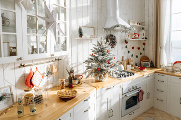 Cozy kitchen bathed in sunlight, adorned with a frosted Christmas tree, red ornaments, festive garlands, and a freshly baked apple pie, perfect for the holiday season