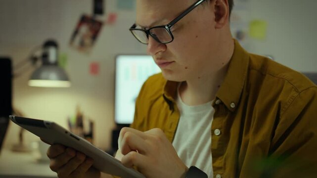 A young college student spends his free time from lectures using his smartphone. In a student dorm, a future technician sits at a computer, enthusiastically studying the gadget's screen