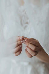 A woman is holding a ring in her hand, and it is a wedding ring. Concept of love and commitment, as the ring is often associated with marriage. The woman's hand is partially covered by a veil