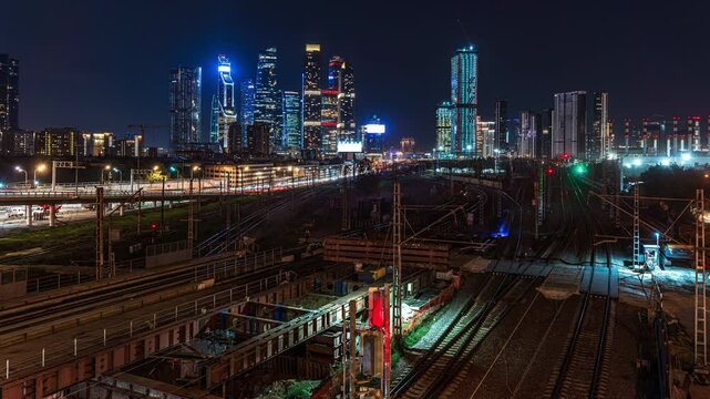 Time-lapse of night traffic with a view of subway trains and cars with headlights