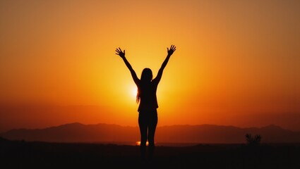 Silhouette of Woman With Arms Raised in Sunset. Golden light hour.