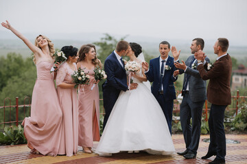 A group of people are gathered on a hillside, with a bride