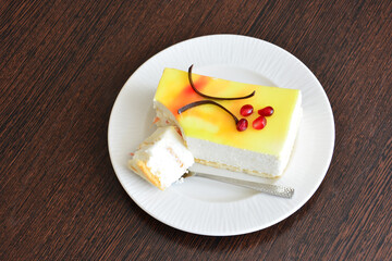 a slice of cheesecake on the white saucer with teaspoon top view 