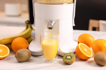 Modern juicer, fresh fruits and glass on white marble table in kitchen, closeup