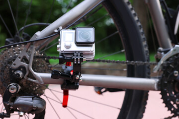 Fototapeta premium Modern action camera with mount on bicycle outdoors, closeup