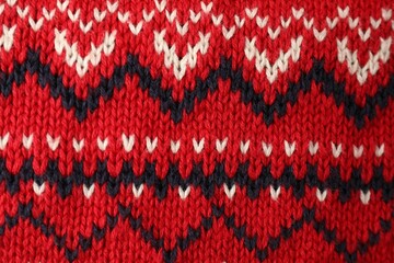 Texture of bright knitted fabric with pattern as background, top view