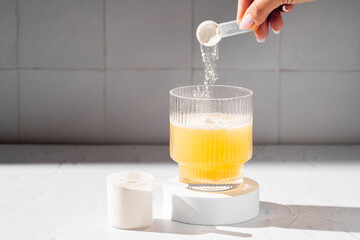 Collagen protein powder in a scoop. Glass of collagen beauty drink. Food supplement.