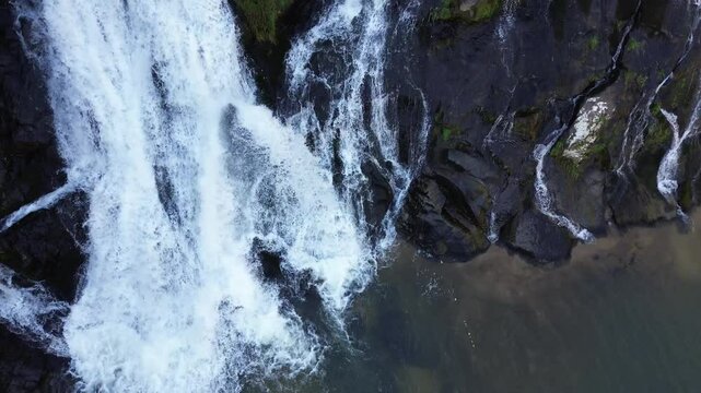 Cacheira acima em uma linda queda de &aacute;gua e meio a pedras e rochas lisas.