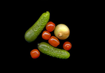 cherry tomatoes, cucumbers and onions on black background