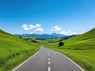 Naklejka premium A peaceful road winding through lush green hills under a clear blue sky, perfect for travel and nature enthusiasts.