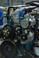 Obraz premium Close-up shot of advanced car engine showing intricate mechanical components and design focusing on various pulleys, belts, and metal parts without green chrome color